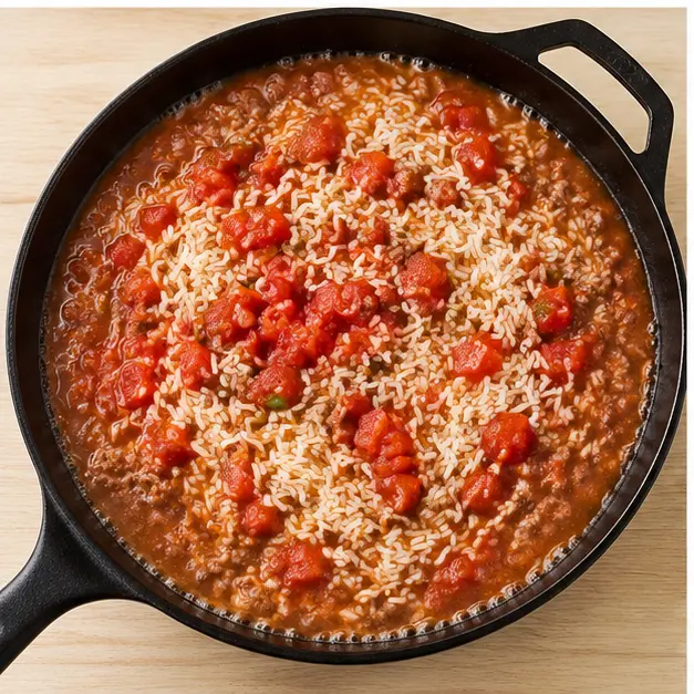 Step 3: Adding long-grain rice, diced tomatoes with green chilies, and beef broth to the skillet