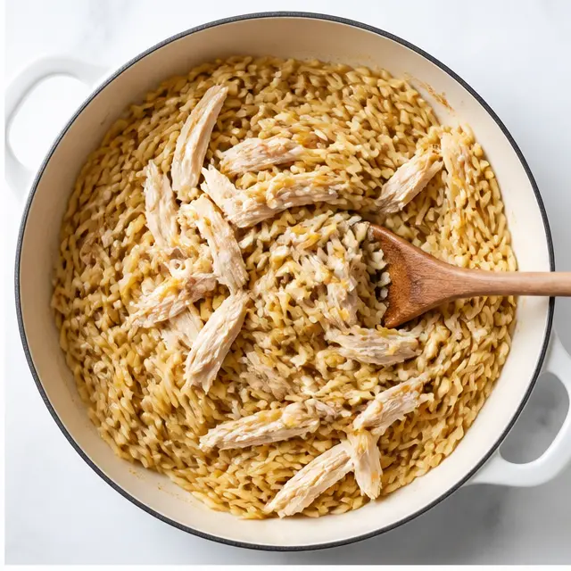 Step 2: Toasting orzo with garlic as shredded chicken is stirred in