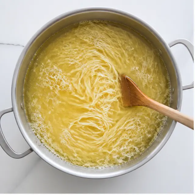 Stage 1: Boiling angel hair spaghetti in low-sodium chicken broth until al dente