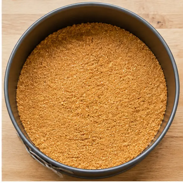 Step 2: Pressing buttery graham cracker crumbs into a springform pan