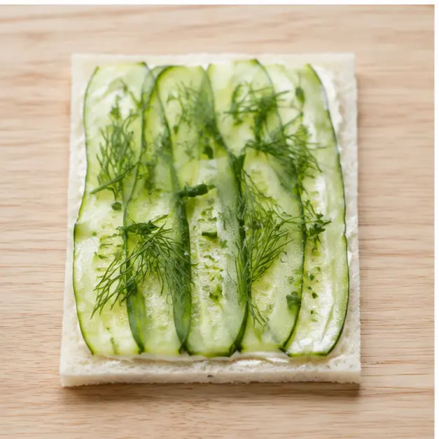 Step 3: Layering cucumber slices and fresh dill over the spread