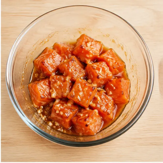 Tossing salmon cubes with the honey garlic glaze