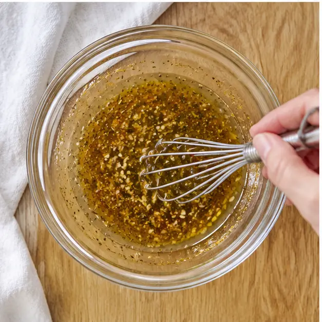 Step 3: Whisking the olive oil vinaigrette with Dijon mustard
