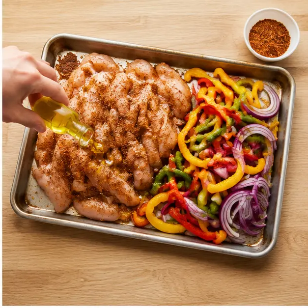 Step 2: Toss sliced chicken and vegetables with olive oil and ground spices on a rimmed sheet pan