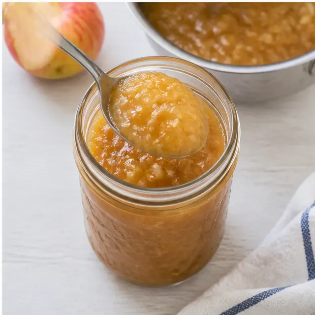 Step 4: transferring thick homemade applesauce into a mason jar
