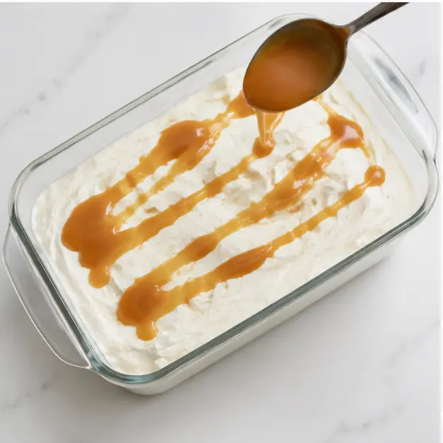 Layering the ice cream base in a glass loaf pan and drizzling caramel sauce