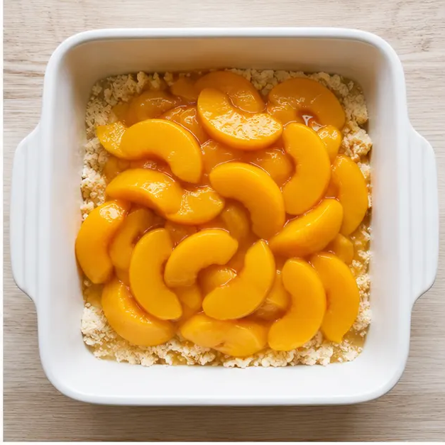 Layering canned peaches over the bottom crumbs