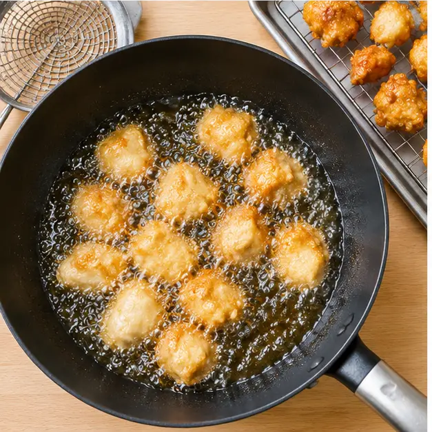 Step 3: Frying battered chicken cubes in 350F oil until deep golden, finished pieces resting on a wire rack